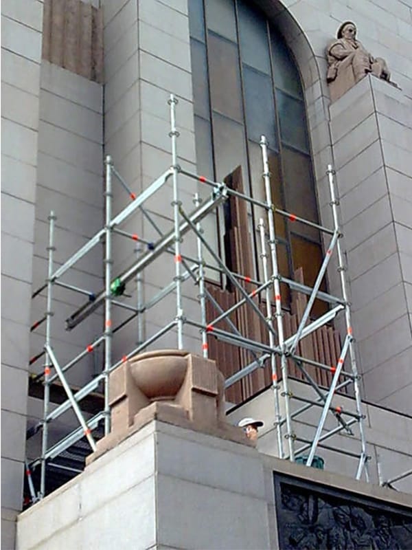Tower scaffold with lifting, beam to hoist cleaning materials and stone panels for repair works (Layher) Ringlock Rymex Scaffolding.